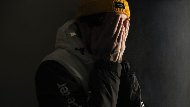man covering his face with both hands