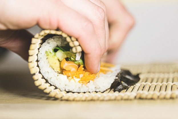 person rolling sushi
