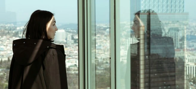 a woman looking out a window at a city