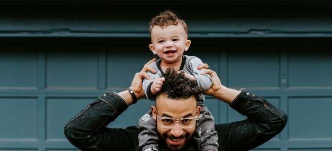 man in black leather jacket carrying boy in black leather jacket