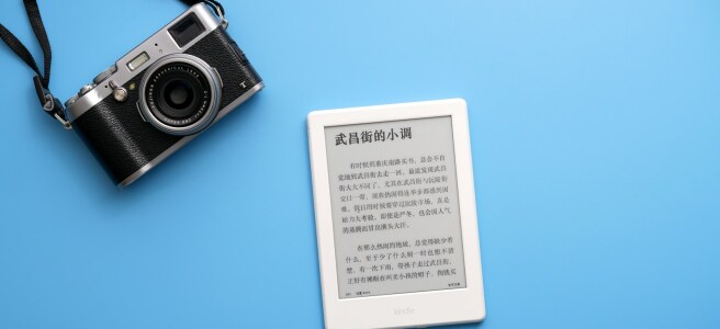 black SLR camera on and white e-book reader