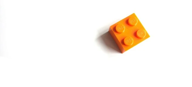 orange mega blocks toy on white surface